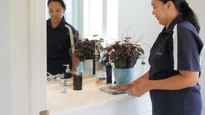 Cleaning worker wiping down vanity top